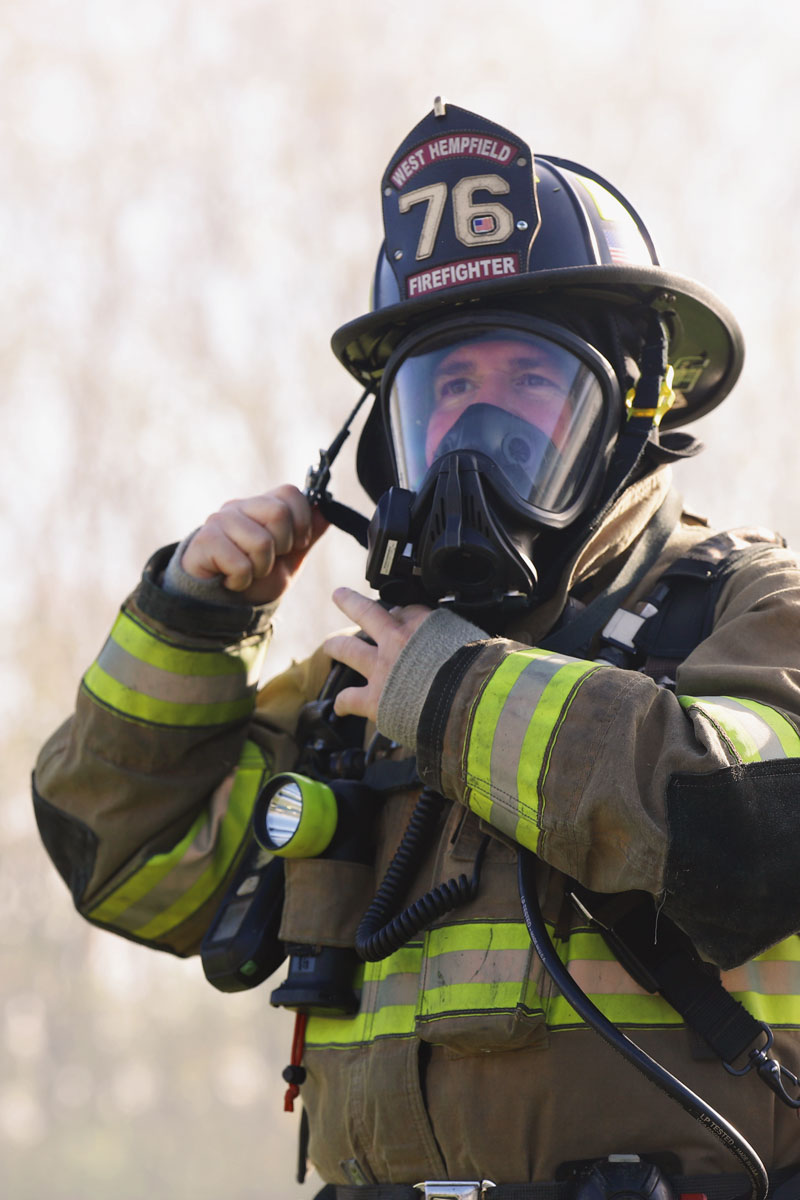 Firefighter adjusting their mask