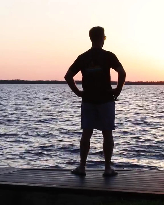 photo from behind of career firefighter Erik Swanson standing on a dock overlooking the water